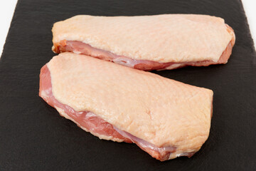 Two fatty duck fillets on black slate plate