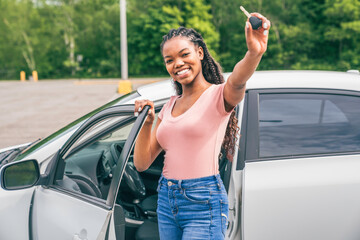 Young black teenage driver seated in her new car