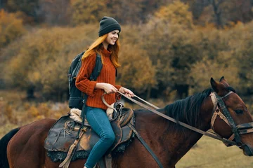 Foto op Canvas cheerful woman hiker riding a horse adventure mountains fresh air © SHOTPRIME STUDIO
