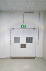 Emergency exit door way with green exit light sign, clean area, walk path way in the GMP factory