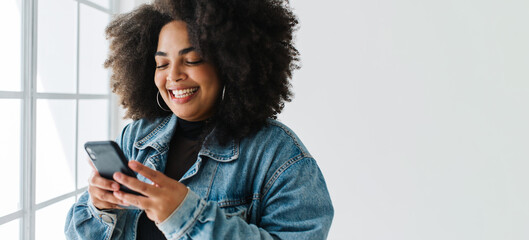 Smiling woman using her mobile phone - Powered by Adobe