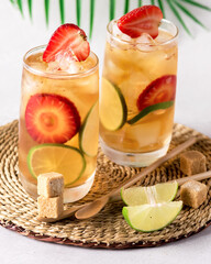 Glasses of Ice Tea with slice of Lime and Strawberry Cold Summer Beverage Vertical