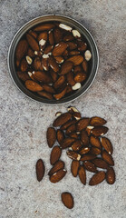 Almonds in rustic bowl on gray background