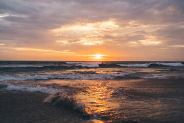 Obraz premium Scenic view of sunset and endless wavy sea