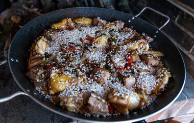 Preparation of typical Spanish food paella with chicken meat pork rice and vegetables