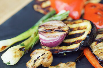 close up of a variety of grilled vegetables served on a stone plate - Powered by Adobe