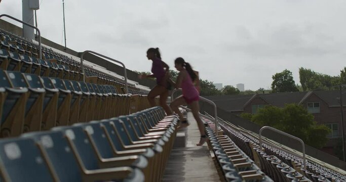 Women climb bleacher stairs in football stadium