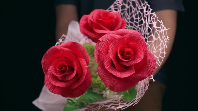 Romantic man give red rose to girlfriend in anniversary event, red roses flower paper in bunch.
