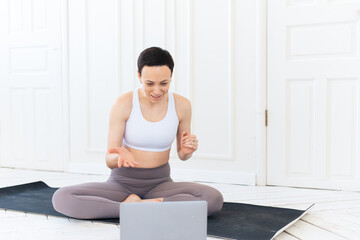 Fototapeta premium Woman with laptop computer at yoga studio. Fitness, technology and healthy lifestyle concept