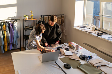 Fashion designers team choose colors and material for new collection. Dressmakers work on clothes...