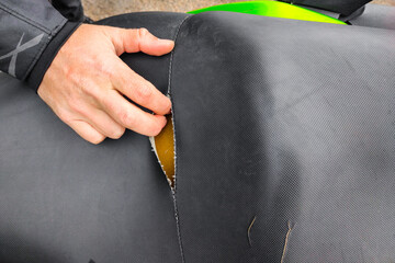 A hole in a motorcycle seat. Genuine leather upholstery has failed over time.
