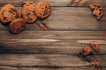 Chocolate aromatic cookies with pieces of cocoa flatley on a background of wooden boards.
