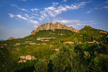 Fototapeta na wymiar Montserrat west face with some rock formations like Roca Foradada and Serrat de la Portella in a summer afternoon (Barcelona province, Catalonia, Spain)