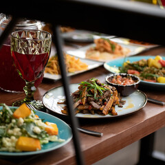 Meals and drinks on festive table in restaurant. Shot through window. Side view. Soft focus.
