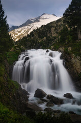 Fototapeta na wymiar Plan and Forau d'Aigualluts (meadow and a waterfall) under the Aneto summit in summer (Benasque, Pyrenees, Spain)