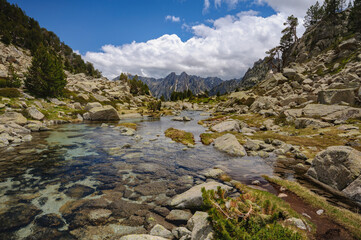 Fototapeta na wymiar Ratera ravine and, in the background, the Encantats summits among the clouds (Sant Maurici, Catalonia, Spain, Pyrenees)