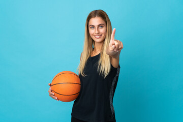 Young woman playing basketball  isolated on white background showing and lifting a finger