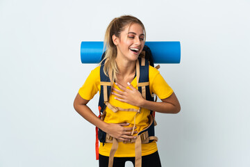 Young mountaineer woman with a big backpack isolated on white background smiling a lot