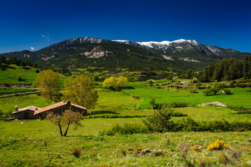 Serra d'Ensija snowy mountain range seen from Gisclareny village in a spring morning (Barcelona province, Catalonia, Spain, Pyrenees)