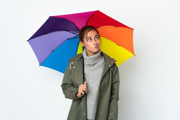 Young woman holding an umbrella isolated on white background and looking up