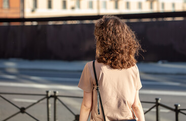 A girl with curly hair on the street