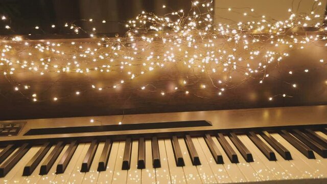 Beautiful synth with Christmas decorations. Close-up synthesizer keys. Synthesizer with New Year's lights.