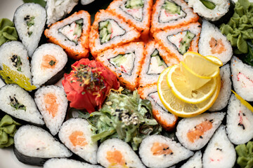 Flat lay. Sushi set, mixed rolls pattern, wallpaper or background. Horizontal format. Traditional Japanese food. Healthy Oriental meal. Wellness concept. Close up shot. Top view. Soft focus.