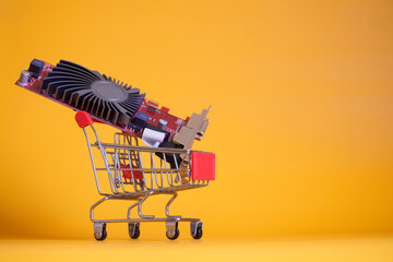 The video card is in a supermarket trolley. The concept of buying and scarcity of modern video cards and investments in blockchain technology. Free space for an inscription
