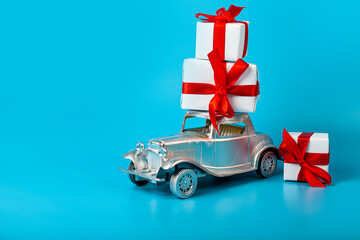 Silver car with gifts on a blue background.