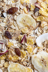 Texture with whole grains for breakfast. Macro close-up. Muesli with dried fruits and dried fruits. Vertical portrait.