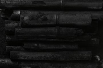 Bamboo charcoal  sticks on coal powder black background..Powerful water purifier