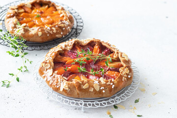 Apricot and plum galette, pie, cake with almond. Summer food.