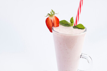 Close-up on strawberry milkshake in the drinking  glass on the white background. Copy space.