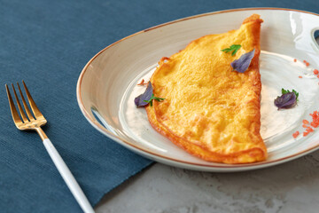 Breakfast omelet on white plate served on table