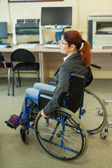 Fototapeta na wymiar Young caucasian woman in a wheelchair in a university auditorium. Inclusive faculty.