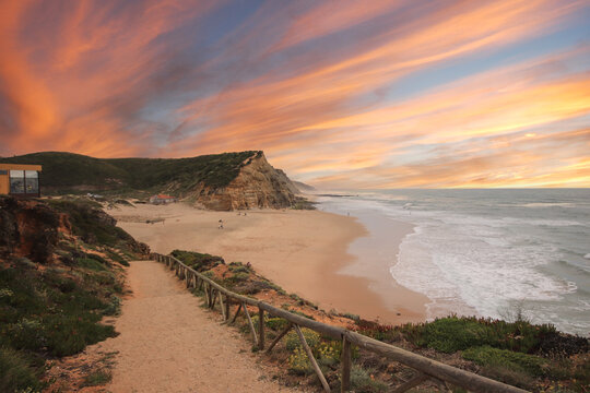 Beautiful sandy ocean beach and cliff at the sunset. Panorama atlantic coastline.