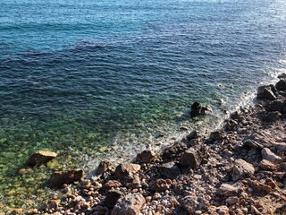 Top view of the beautiful waves of the mediterranean sea breaking on the coast of the rocky coast