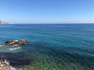 Top view of the beautiful waves of the mediterranean sea breaking on the coast of the rocky coast