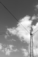 Electric pole with wires against the blue sky	