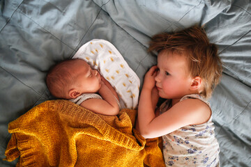 cute baby siblings sleep together, newborn baby and toddler older sister, sibling relationship in...