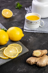 Sicilian lemon tea, ginger and mint leaves on slate stone