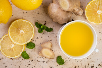 Sicilian lemon tea, ginger and mint leaves on white marble stone