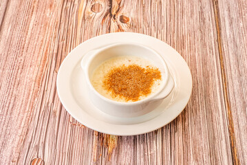 white porcelain bowl with rice pudding topped with brown sugar and cinnamon