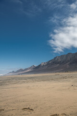 cofete beach with an expanse of mountains on a sunny day in fuerteventura