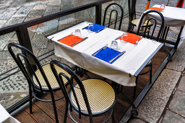 Tables and chairs of traditional outdoor Italian cafe in Florence, cloudy day, Tuscany, Italy