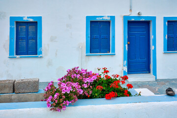 Fototapeta na wymiar Greek white house with blue door and window blinds Oia village on Santorini island in Greece