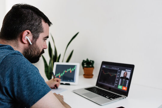 Hispanic student making a video call with a professional trader to learn how to trade the stock market and the cryptocurrency market. Investment and financial concept