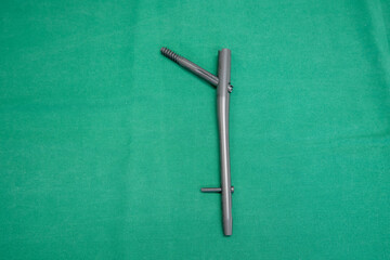 an explanted femoral nail lies on a green surgical drape