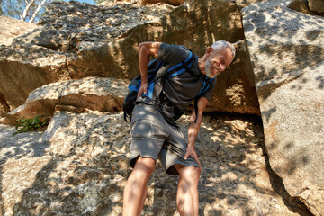 Middle aged caucasian man with aching back climbing