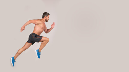 sportsman man runner run to success or jump high on grey background, copy space, sport